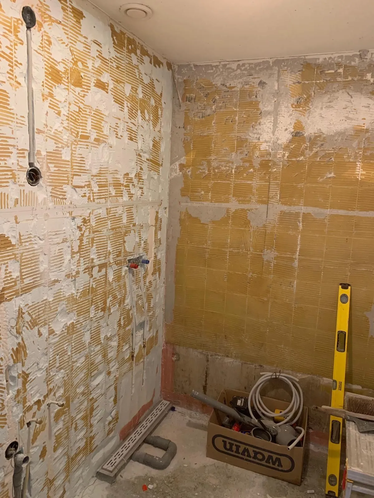 Badkamer tijdens de verbouwing: kale wanden en leidingwerk (projectfoto bij review van Partoredjo)