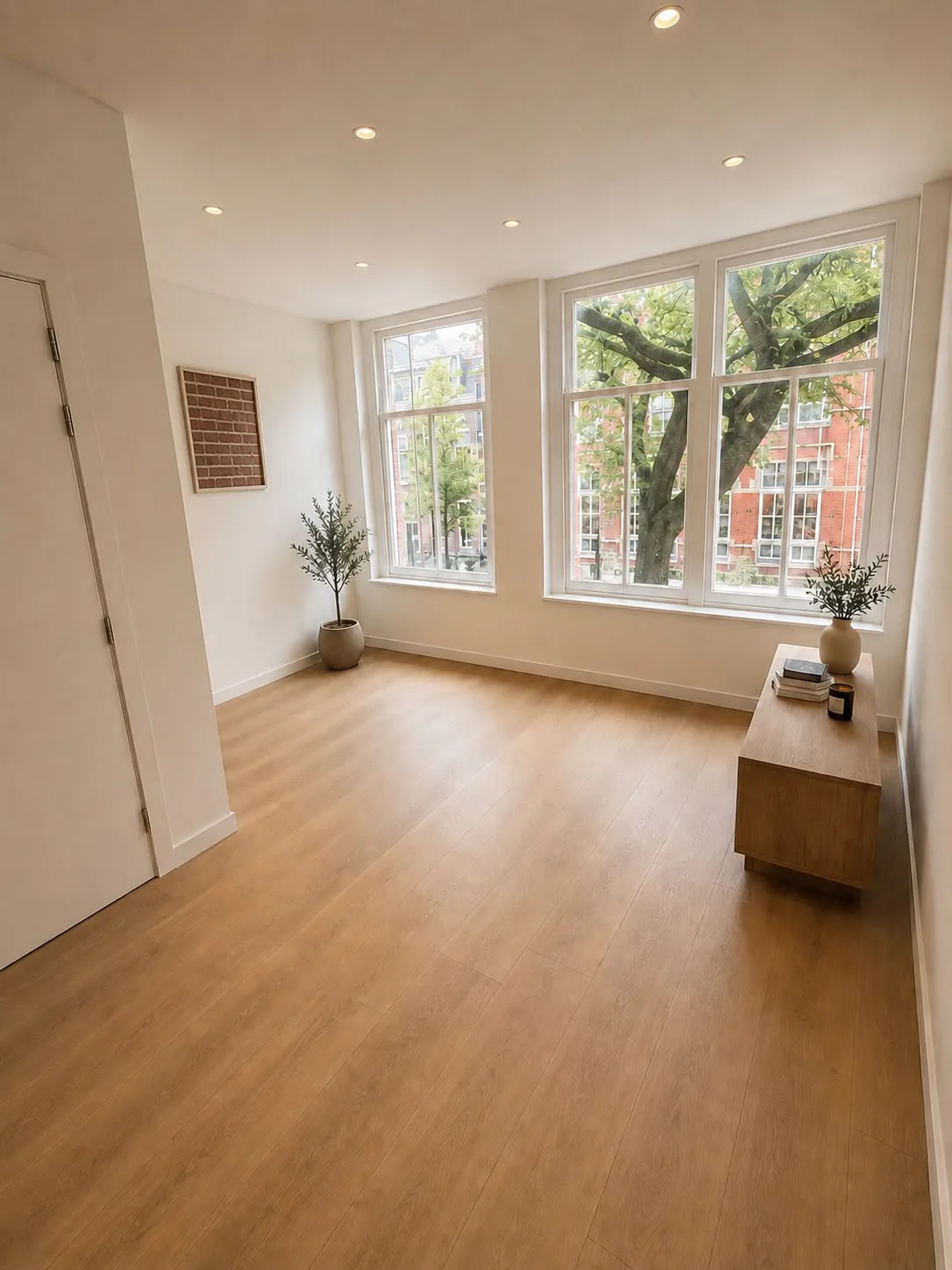 Lichte kamer met houten vloer en grote ramen